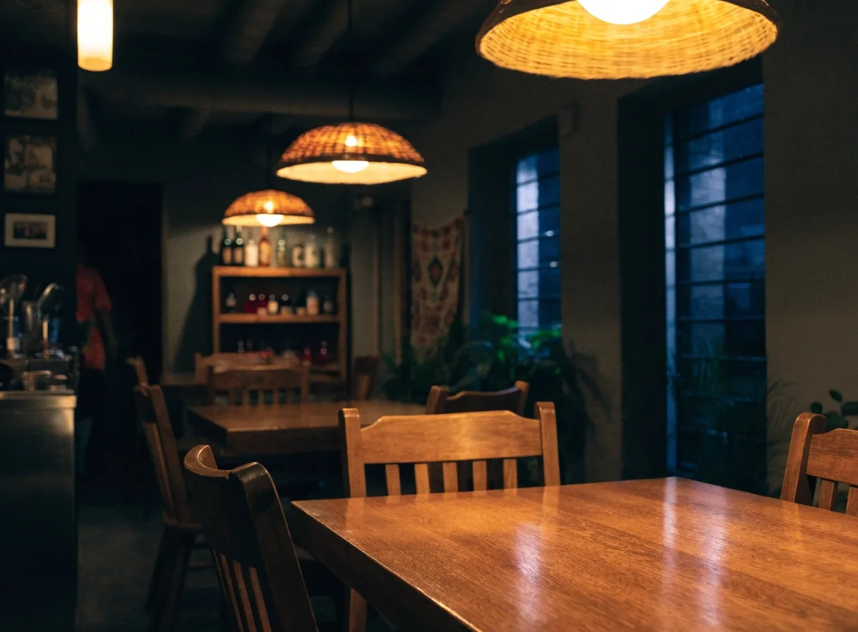 Warm dining room with tables under pendant lamps at night